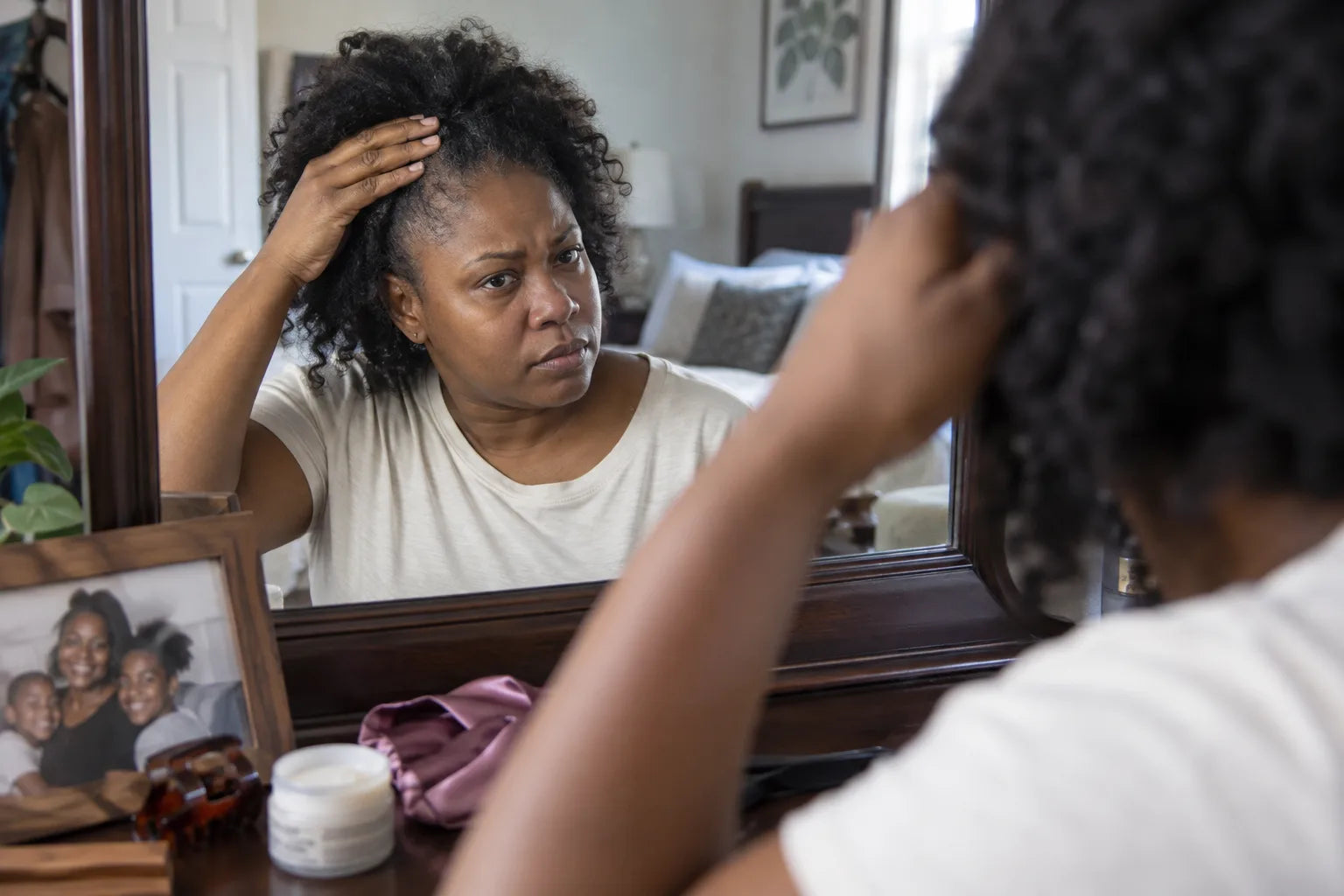 A woman checking the hairline at her temple